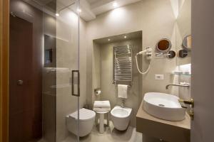 a bathroom with a sink and a toilet and a mirror at Montespina Park Hotel in Naples