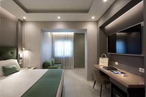 a hotel room with a bed and a desk and a tv at Montespina Park Hotel in Naples