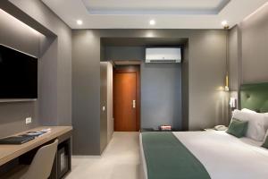a bedroom with a bed and a desk and a television at Montespina Park Hotel in Naples