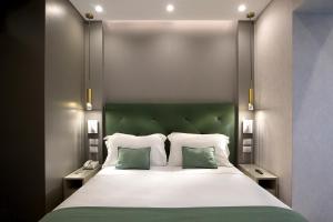 a bedroom with a large bed with two green pillows at Montespina Park Hotel in Naples