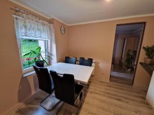 a dining room with a white table and chairs at Apartament Strzyżowiec 80 in Czernica