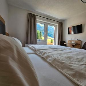 a bedroom with a large bed with a large window at Bergkristall B&B in Berwang