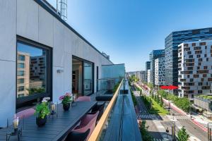a balcony with pink chairs and tables on a building at Spacious modern 3BR apartment at CENTRAL OSLO barcode in Oslo