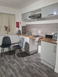 a kitchen with two chairs and a counter top at Super airy studio, free parking in Birmingham