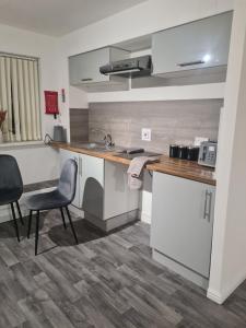a kitchen with a counter and chairs in a room at Super airy studio, free parking in Birmingham