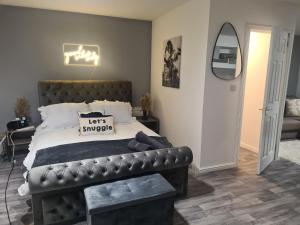 a bedroom with a large bed with a leather headboard at Super airy studio, free parking in Birmingham