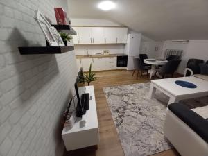 a living room with a couch and a table with a tv at Sweet home in Brčko