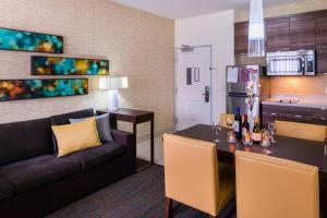 a living room with a couch and a table and a kitchen at Residence Inn by Marriott Temecula Murrieta in Murrieta