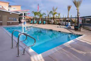 a swimming pool at a resort with chairs and palm trees at Residence Inn by Marriott Temecula Murrieta in Murrieta