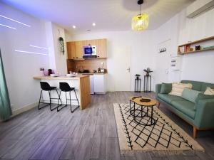 ein Wohnzimmer mit einem grünen Sofa und einer Küche in der Unterkunft EL NIDO by LimogesBNB in Limoges