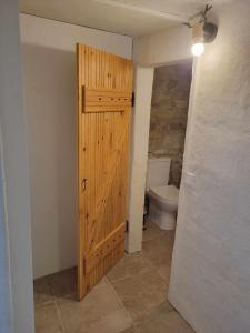 baño con puerta de madera y aseo en Maison des biches, en Saint-Jean-et-Saint-Paul