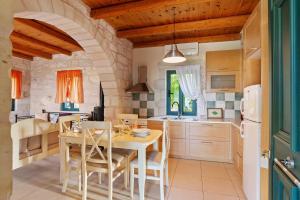 a kitchen with a table and chairs in a room at Villa Terpsichore St George Retreat BY APOKORONAS-VILLAS in Kókkinon Khoríon