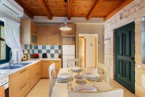 a kitchen with a table and chairs and a kitchen with a sink at Villa Terpsichore St George Retreat BY APOKORONAS-VILLAS in Kókkinon Khoríon +31 photos