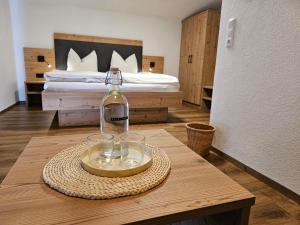 a bottle of wine on a table in a bedroom at Bergkristall B&B in Berwang