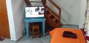 a room with a desk with a television and a staircase at El Maiten Bariloche in San Carlos de Bariloche