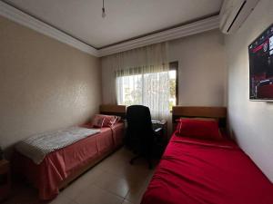 1 dormitorio con 2 camas y ventana en Appartement a Saidia Perla Gh1, en Saidia 