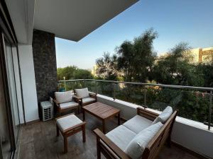 Un balcón con sillas y mesas. en Appartement a Saidia Perla Gh1, en Saidia 