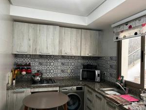cocina con lavadora y microondas en Appartement a Saidia Perla Gh1, en Saidia 