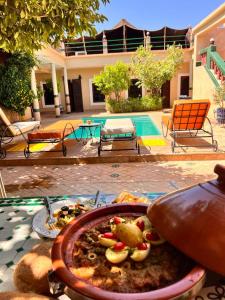 un plato de comida en una mesa frente a una casa en Riad Rime Garden Marrakech en Marrakech