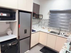 a small kitchen with a refrigerator and a sink at Brand New Exclusive Condo with Pool and Gym in Port Harcourt