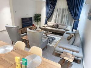 ポートハーコートにあるBrand New Exclusive Condo with Pool and Gymのソファと椅子とテレビのあるリビングルーム