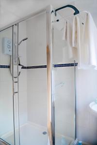 a shower with a glass door in a bathroom at Entire apt. quiet area near Leeds Castle Maidstone in Harrietsham