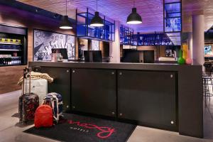 埃森的住宿－Moxy Essen City，一间酒吧,上面有黑色的柜台,上面有红色的袋子