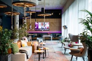 a lobby with couches and tables and potted plants at Moxy Essen City in Essen
