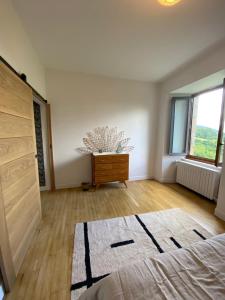 a bedroom with a bed and a dresser and a window at La maison de Marie in Junhac