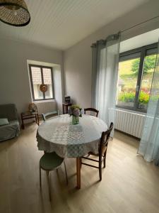 a dining room with a table and chairs and a window at La maison de Marie in Junhac