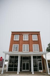 un bâtiment en briques rouges avec des fenêtres et un panneau d'arrêt dans l'établissement Bricktown Inn, 