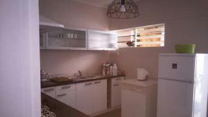 a kitchen with white cabinets and a white refrigerator at La Minaude in Saint-Denis