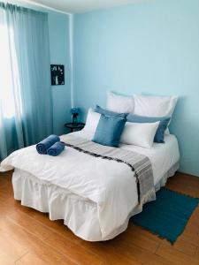 a bedroom with a large white bed with blue walls at Classic Holiday in New Germany