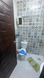 a bathroom with a toilet and a tile wall at Arabian Nights Pyramids Guesthouse in Cairo
