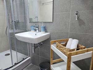 a bathroom with a sink and a shower at Sun&Moon Apartments in Novi Sad