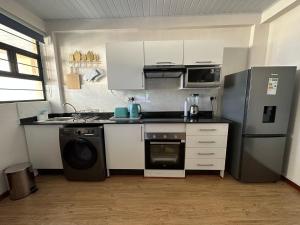 a kitchen with a stove and a refrigerator and a dishwasher at Exquisite short and long stay in Gaborone