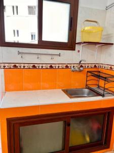 a kitchen counter with a sink and two windows at Appartement Cosy quartier chic de Rabat in Rabat