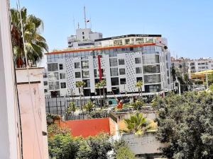 un grande edificio bianco con palme di fronte di Appartement Cosy quartier chic de Rabat a Rabat
