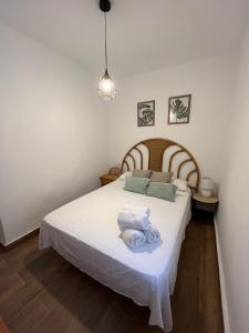een slaapkamer met een bed met witte lakens en een lamp bij Apartamento Cabo Polonio in Tarragona