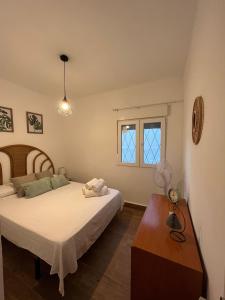 een slaapkamer met 2 bedden, een tafel en een raam bij Apartamento Cabo Polonio in Tarragona
