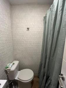 een badkamer met een toilet en een douchegordijn bij Apartamento Cabo Polonio in Tarragona