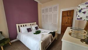 a bedroom with a white bed and a table and a window at Castle Brae Apartment in Stirling