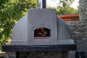 um forno de pedra com um fogo dentro dele em Loo kodu&köök em Muraste