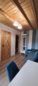 ein Wohnzimmer mit einem Sofa und einer Holztür in der Unterkunft Morski 1 in Stegna