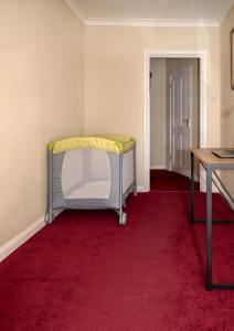Cette chambre comprend un lit et un tapis rouge. dans l'établissement Entire apt. quiet area near Leeds Castle Maidstone, à Harrietsham