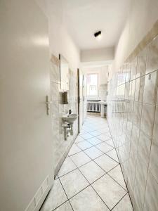 a bathroom with a sink and a tiled hallway at BLUE Hostel - Private Rooms by Friendly Hostel in Poznań