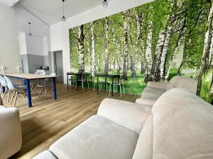 sala de estar con sofá, mesa y árboles en BLUE Hostel - Private Rooms by Friendly Hostel en Poznan