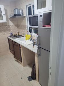 a kitchen with a refrigerator and a sink at Maison S1 in Mahdia +5 photos