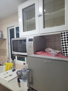 a kitchen with a microwave on top of a refrigerator at Maison S1 in Mahdia