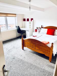 a bedroom with a large wooden bed and a desk at Private Room close to Leeds University and City centre in Leeds